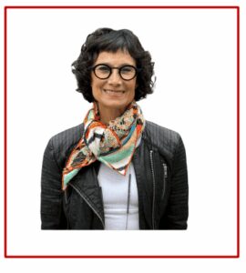 Woman with glasses and colorful scarf smiling.