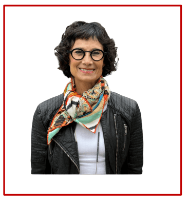 Smiling woman with glasses wearing a leather jacket and patterned scarf.