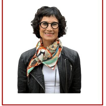 Woman with glasses and colorful scarf smiling.